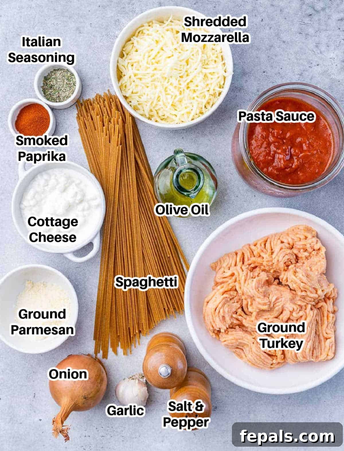 A collection of fresh ingredients neatly arranged for Million Dollar Spaghetti, including pasta, sauce, ground meat, cheeses, and spices.