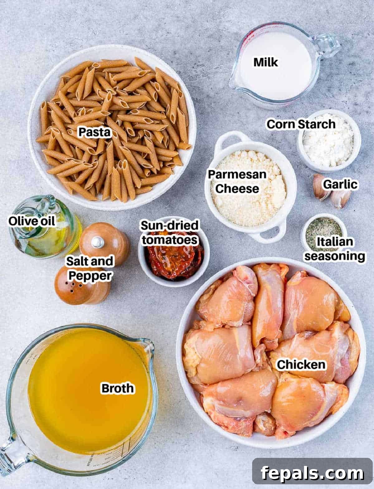 A vibrant flat lay of all fresh ingredients needed for Marry Me Chicken Pasta, including penne, chicken, sun-dried tomatoes, and spices.