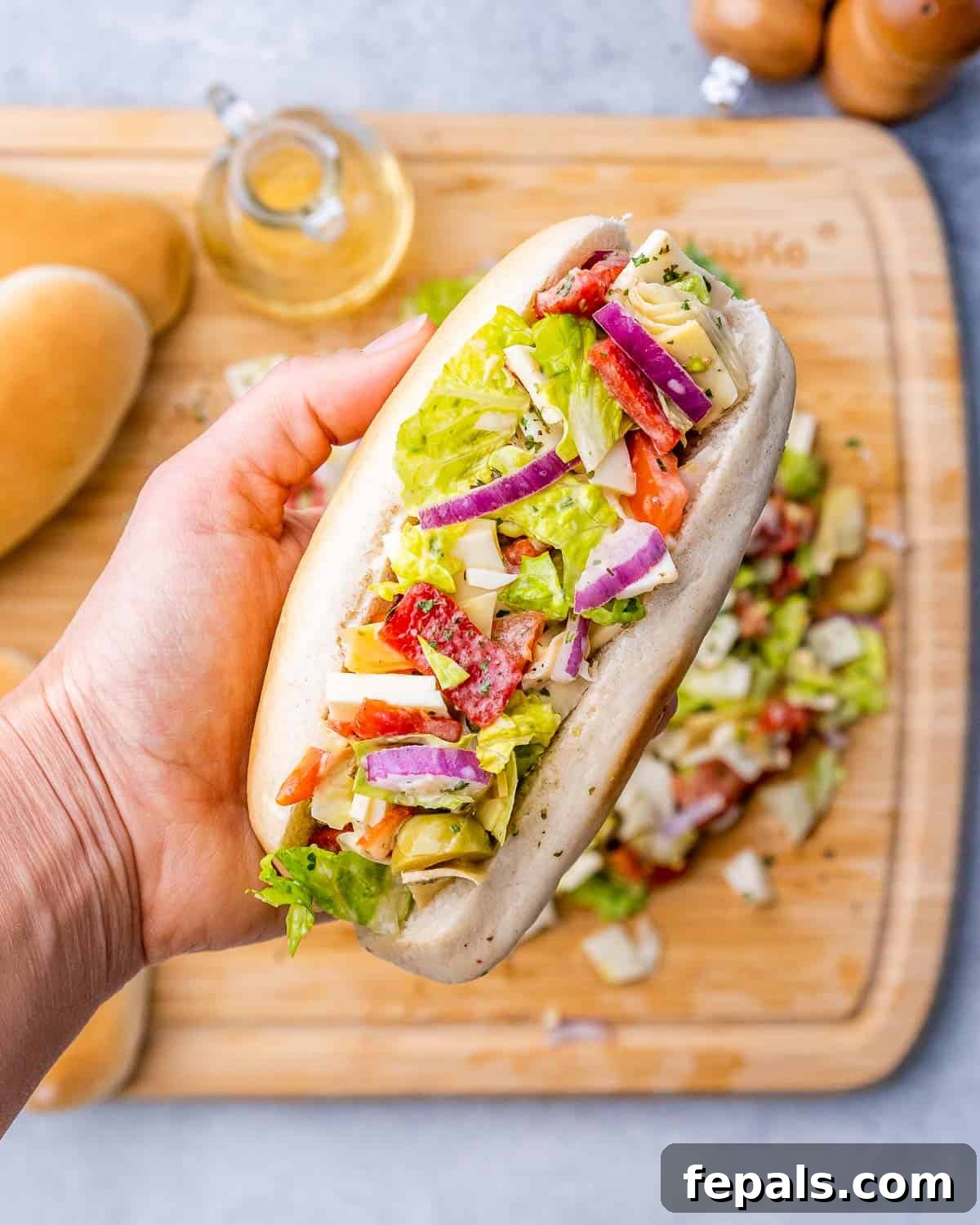 Ultimate Chopped Italian 3 Hand holding up chopped Italian sandwich.