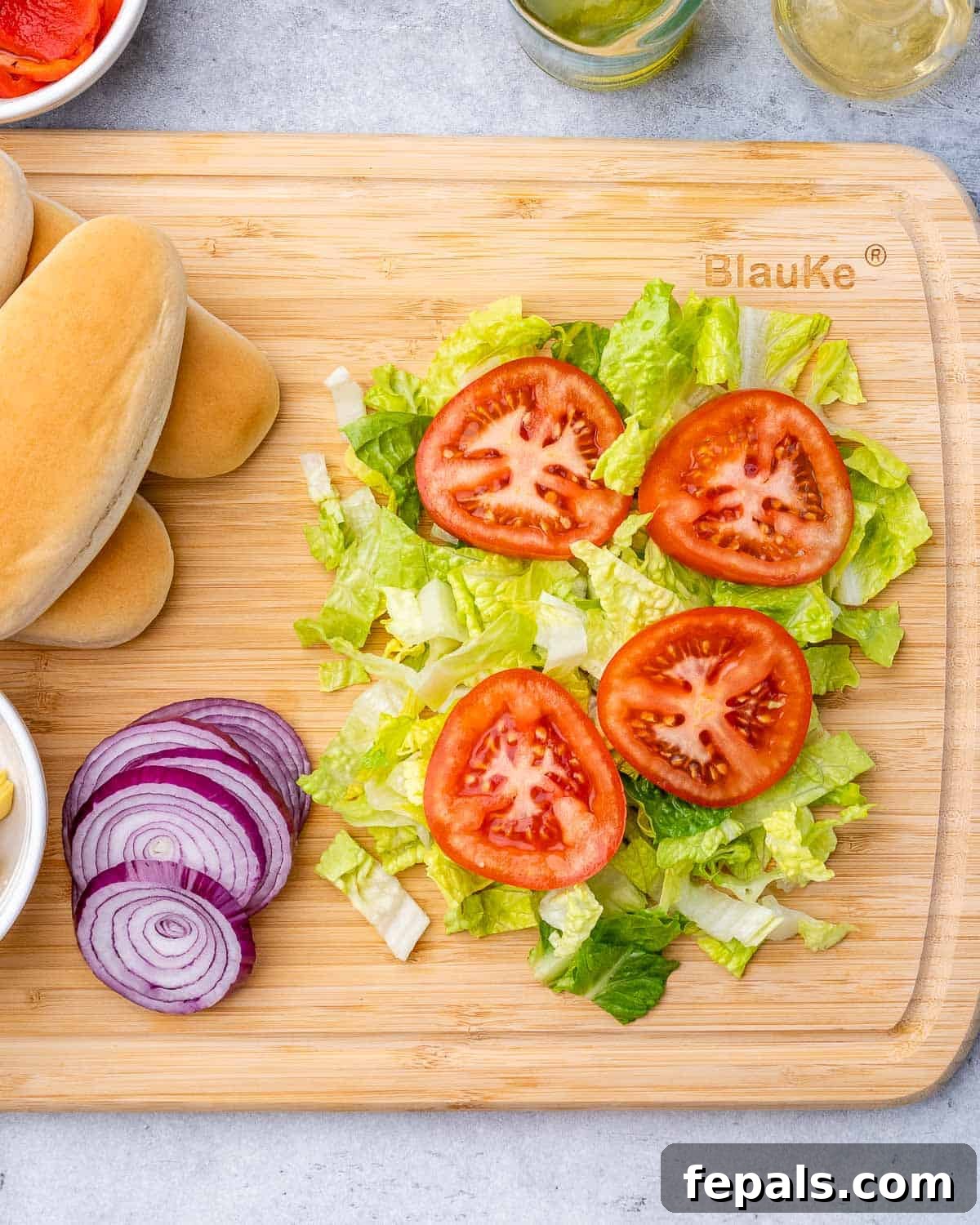 Ultimate Chopped Italian 5 Lettuce, tomato and onions on a cutting board.