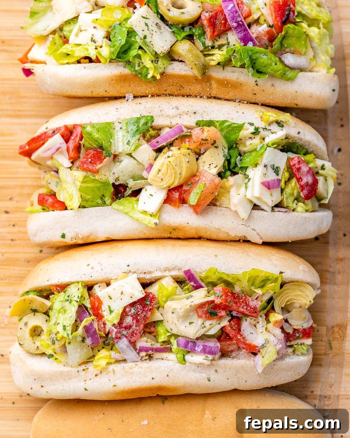 Ultimate Chopped Italian 9 3 buns on a cutting board filled with chopped salad.