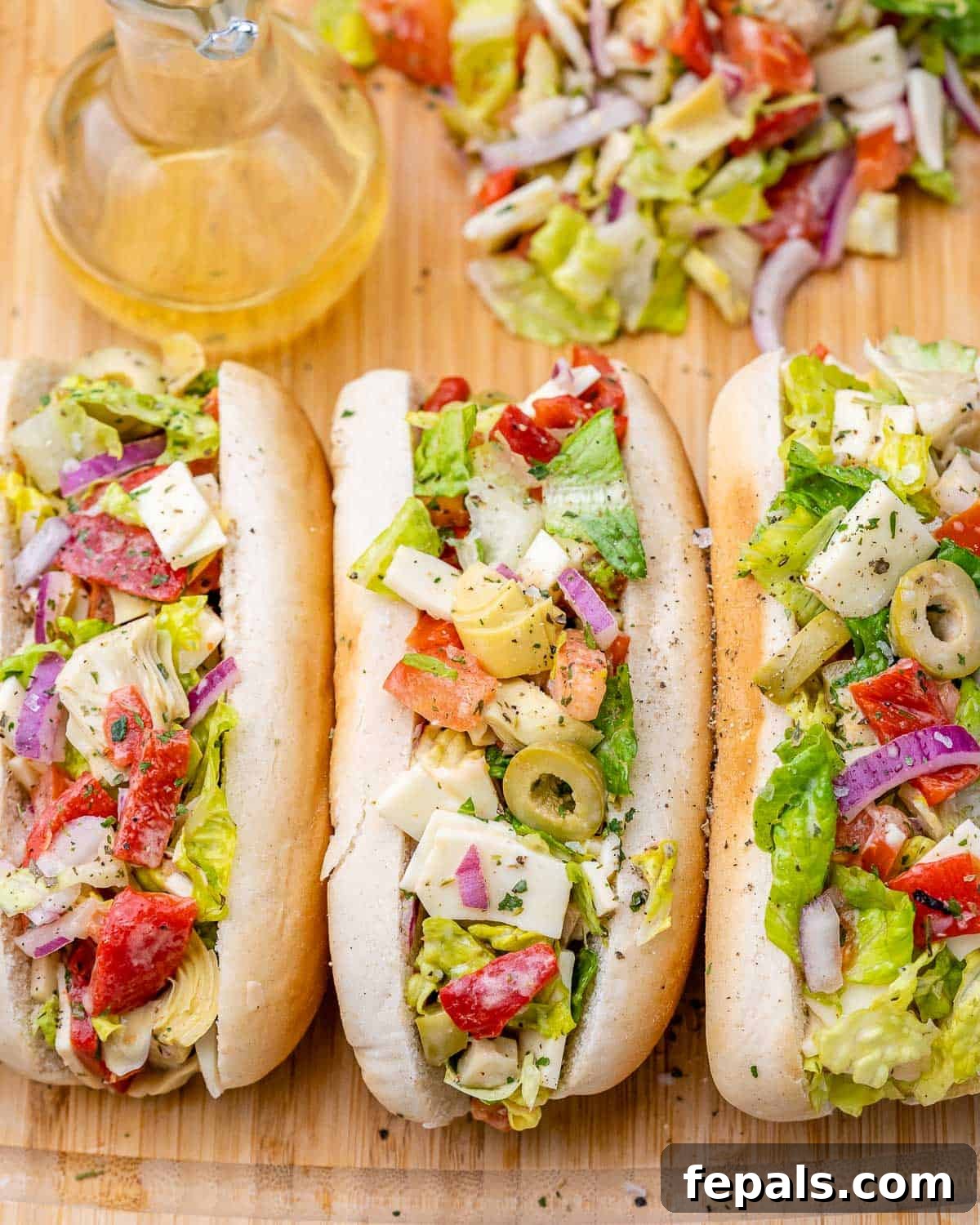 Ultimate Chopped Italian 10 Chopped Italian sandwiches on a wooden cutting board.