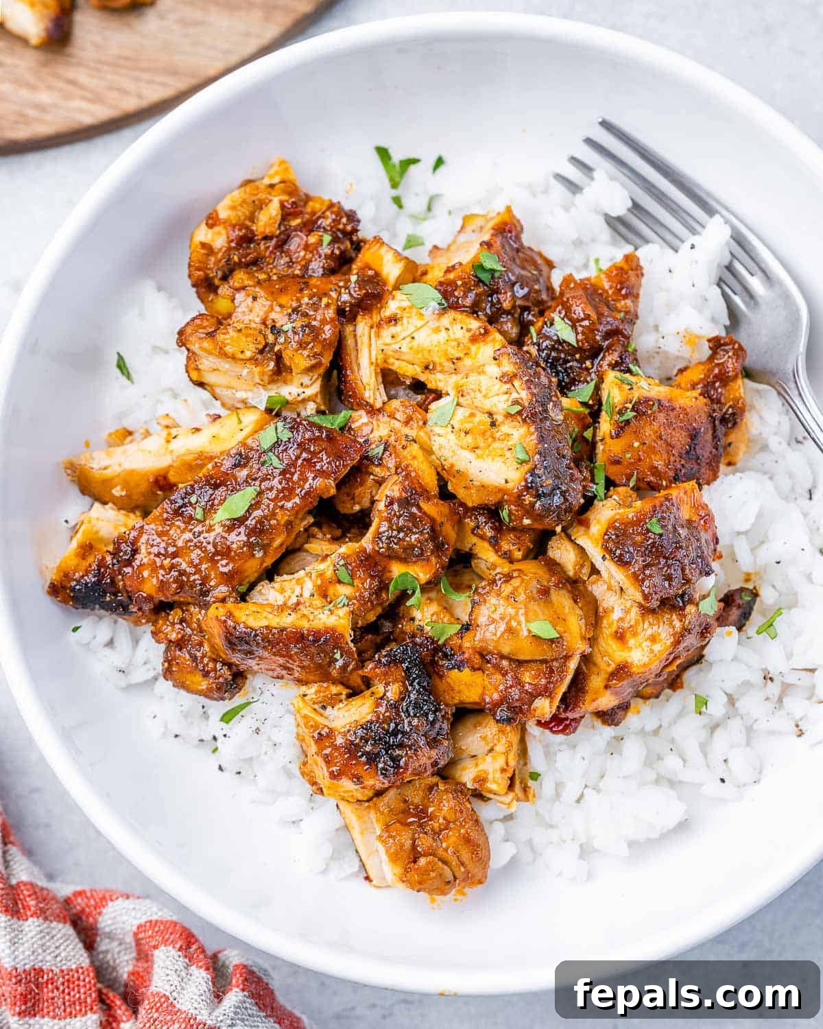 Smoky Chipotle Al Pastor Chicken 2 A perfectly portioned bowl of homemade Chipotle Chicken Al Pastor, served over fluffy white rice, with a fork poised for a delicious bite.