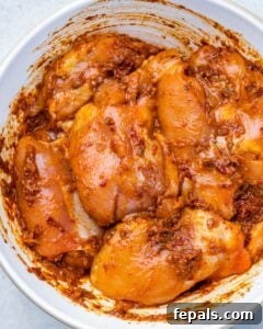 Smoky Chipotle Al Pastor Chicken 9 raw marinated chicken with the al pastor sauce in a round bowl.