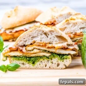 Chicken Parmesan Sandwiches sliced and arranged on a cutting board, served with fresh basil and a rustic look.