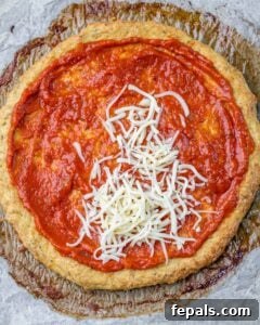 Pizza crust topped with marinara and mozzarella.