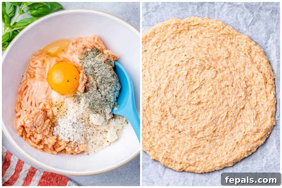 Process shot showing the seasoned ground chicken mixture being evenly spread onto a prepared baking sheet lined with parchment paper, forming a thin pizza crust.