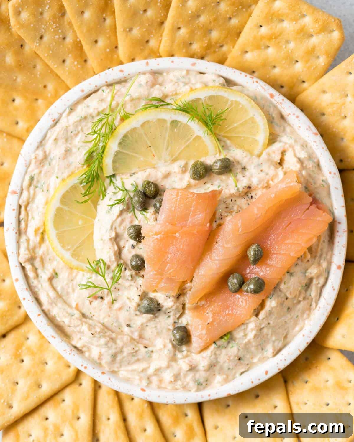 Smoked salmon dip garnished with capers, dill and lemon slices.