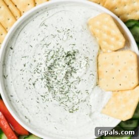 Protein-Packed Ranch Dip 11 creamy ranch dip in a bowl with crackers in dip and fresh dish garnish