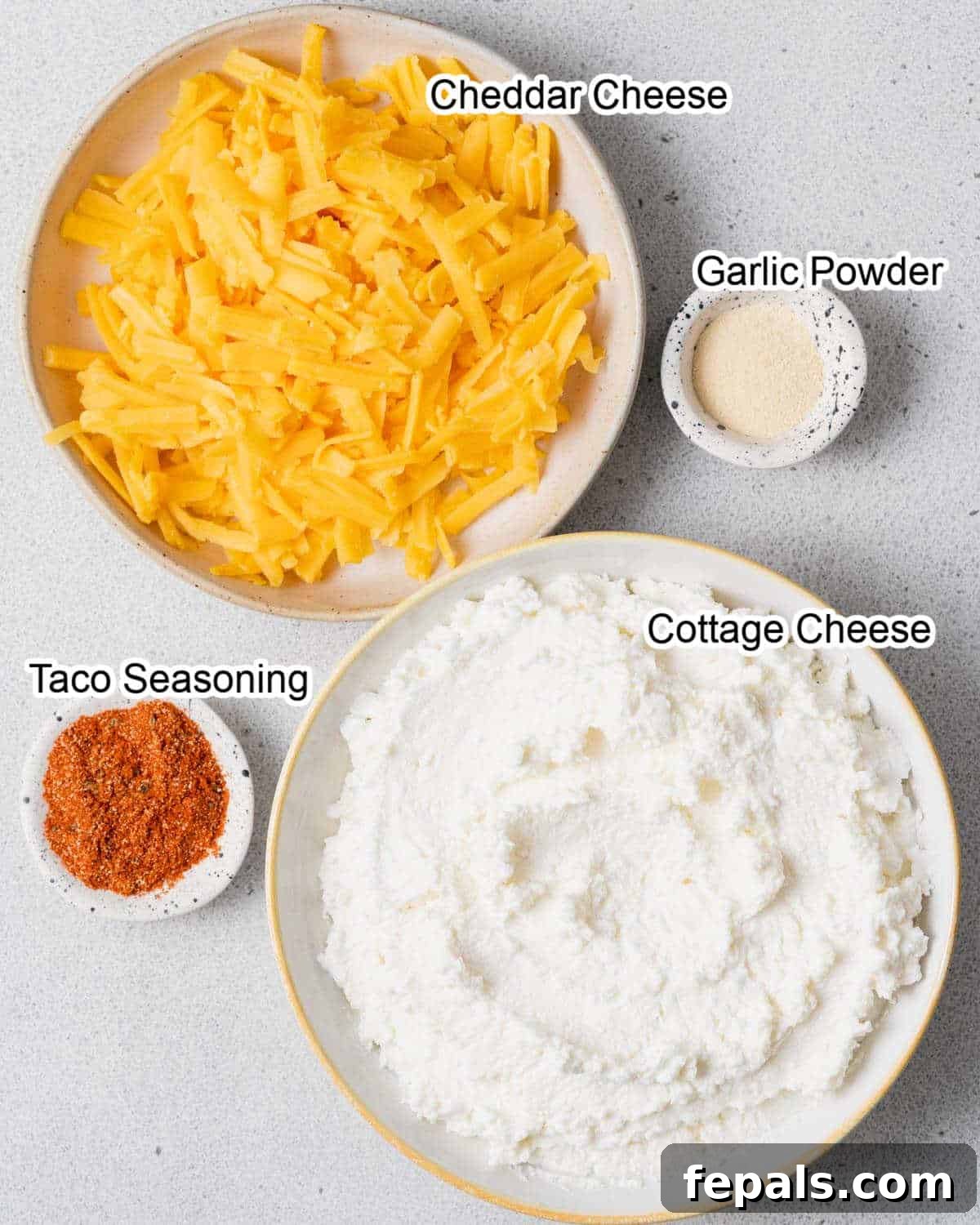 The Creamy Cottage Cheese Queso Hack 4 All the fresh ingredients laid out to make the high-protein cottage cheese queso, including a tub of cottage cheese, shredded cheese, and various seasonings.