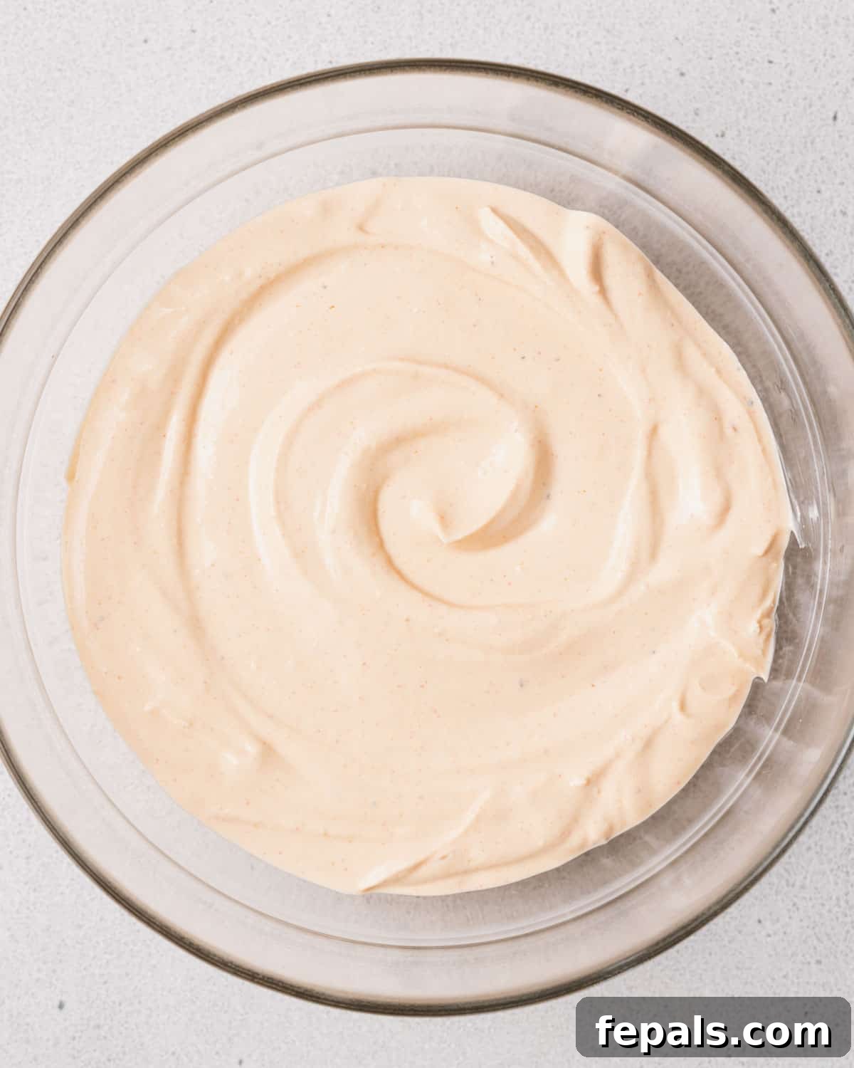 The Creamy Cottage Cheese Queso Hack 7 The smoothly blended cottage cheese mixture transferred into a clear glass bowl, ready for the next step.