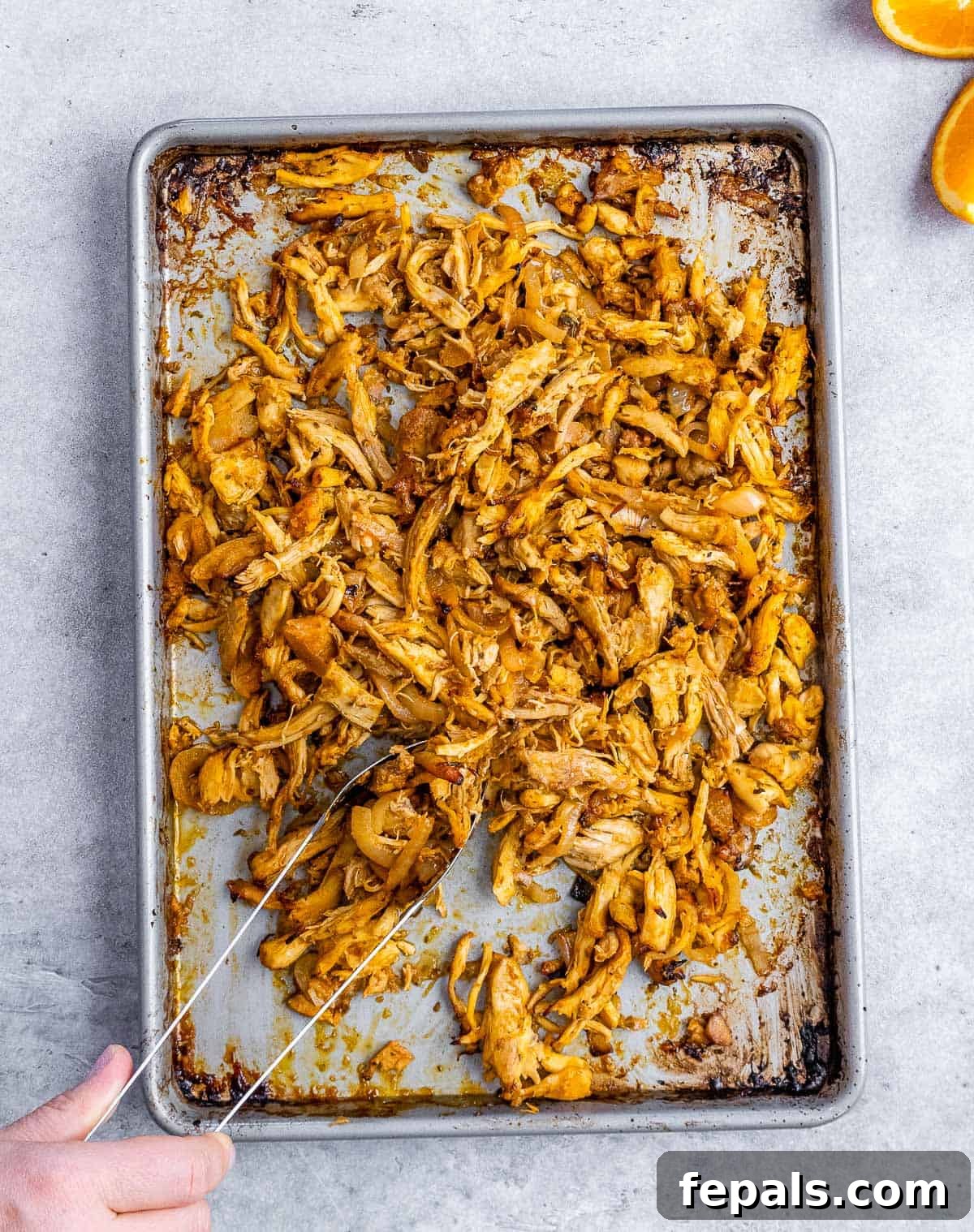 Crispy Pulled Chicken Carnitas 7 Shredded chicken spread out evenly on a sheet pan, being broiled to achieve golden, crispy edges.