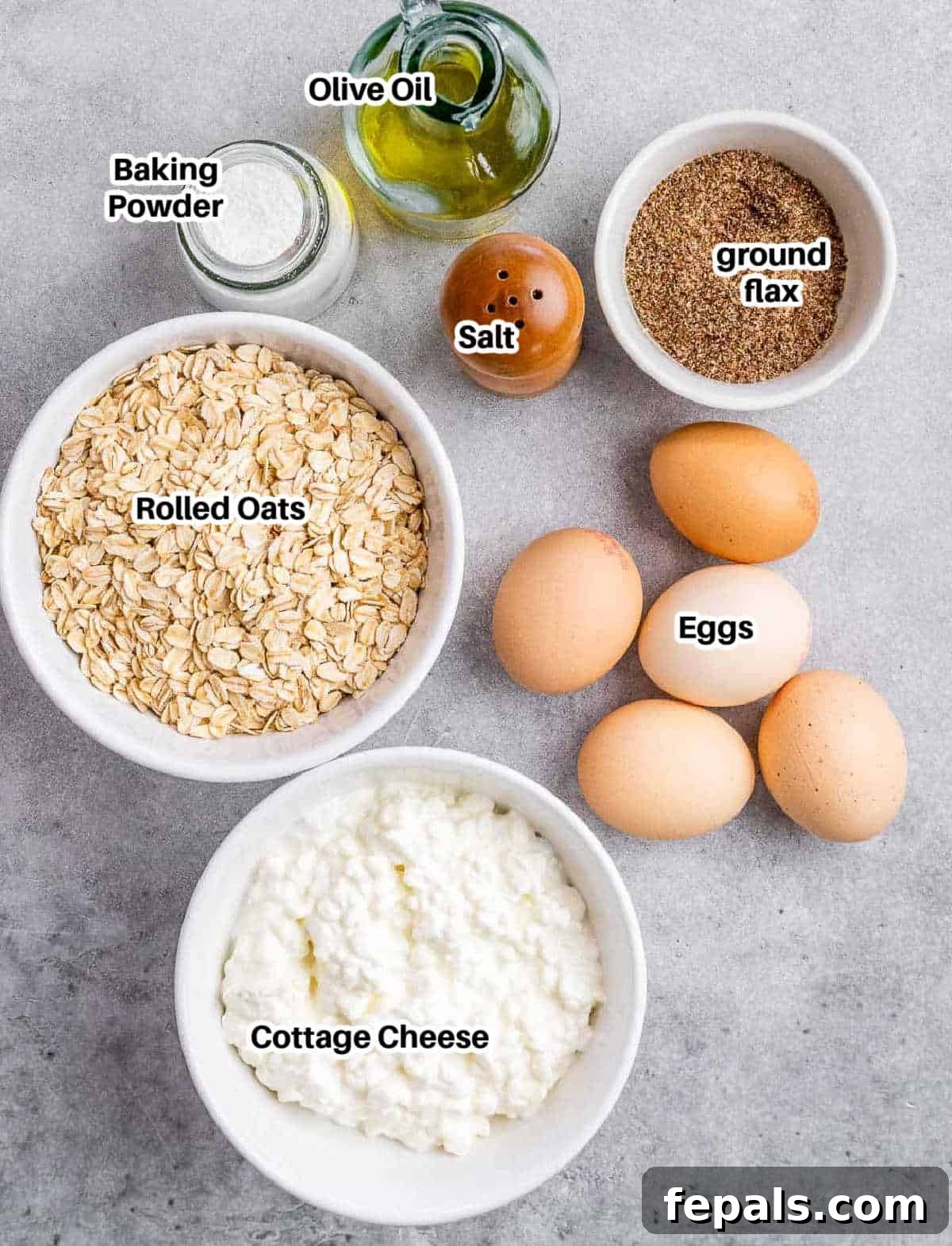 Golden Cottage Loaf 4 A collection of essential ingredients for making cottage cheese bread, including oats, cottage cheese, eggs, and olive oil, laid out on a kitchen counter.