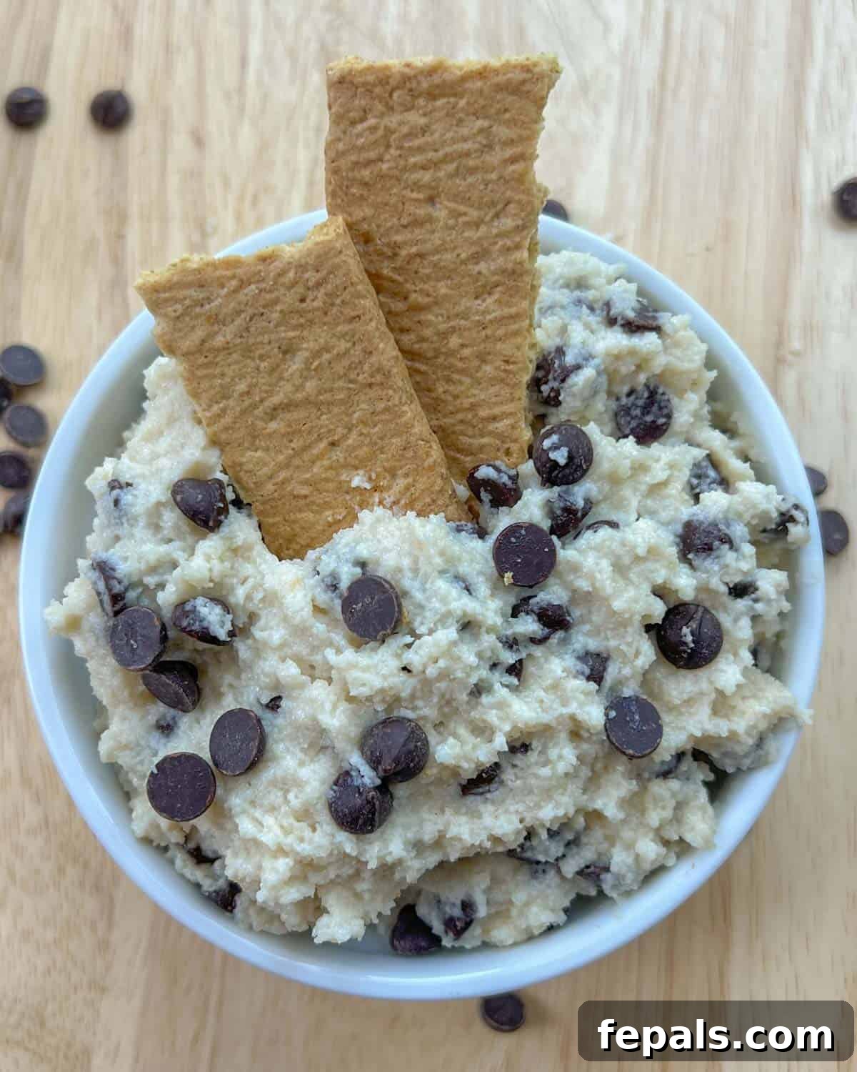 Protein-Packed Cookie Dough Delight 2 A perfectly portioned bowl of cottage cheese cookie dough, garnished with two crispy crackers, inviting you to dive in.