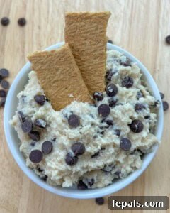 cookie dough in a round bowl with 2 crackers in the cookie dough.