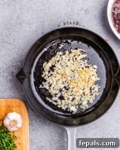 Effortless Flavorful Shredded Chicken Tacos 6 Diced onion and garlic being sautéed in a skillet, part of the filling prep.