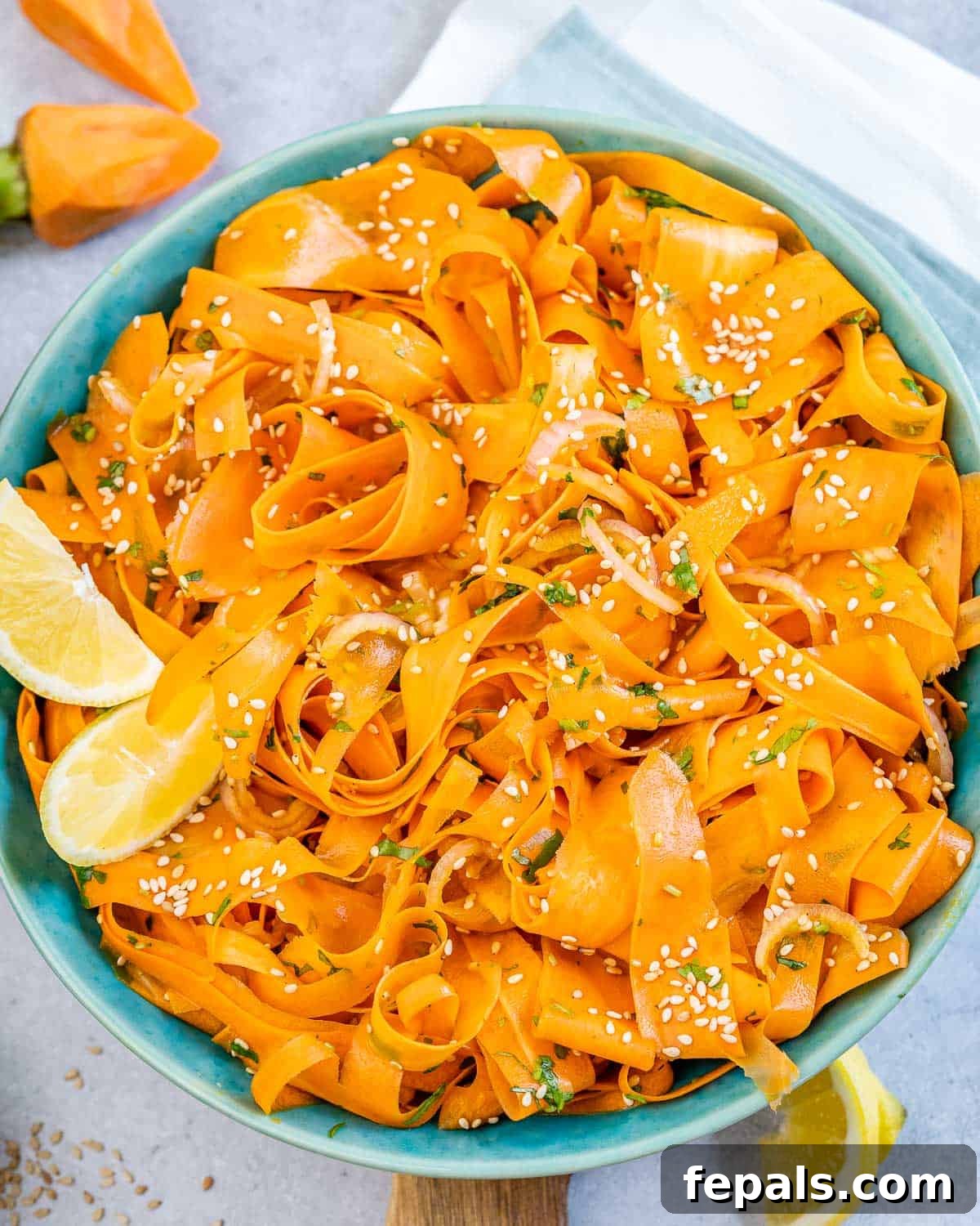 Viral Carrot Salad Sensation 2 A vibrant blue bowl filled with a fresh, sliced carrot salad, ready to be served.