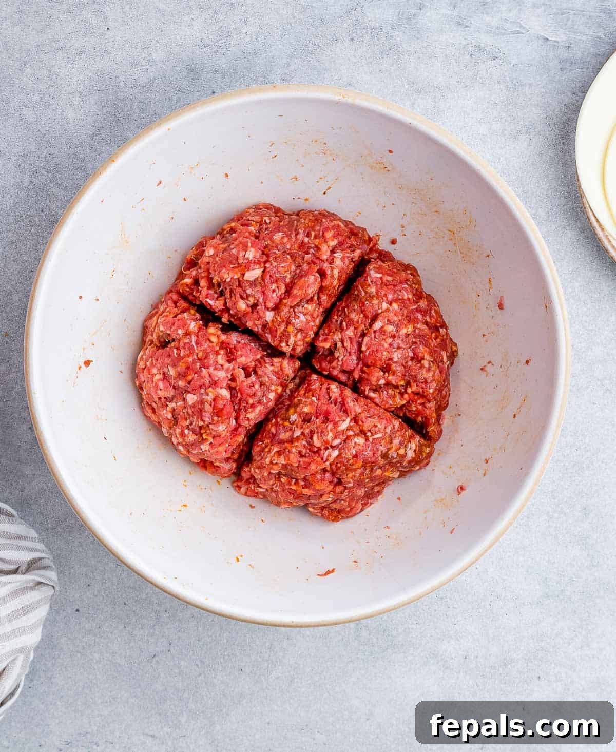 Burger Perfection, Made Easy 4 Forming ground beef into a patties on a white plate.