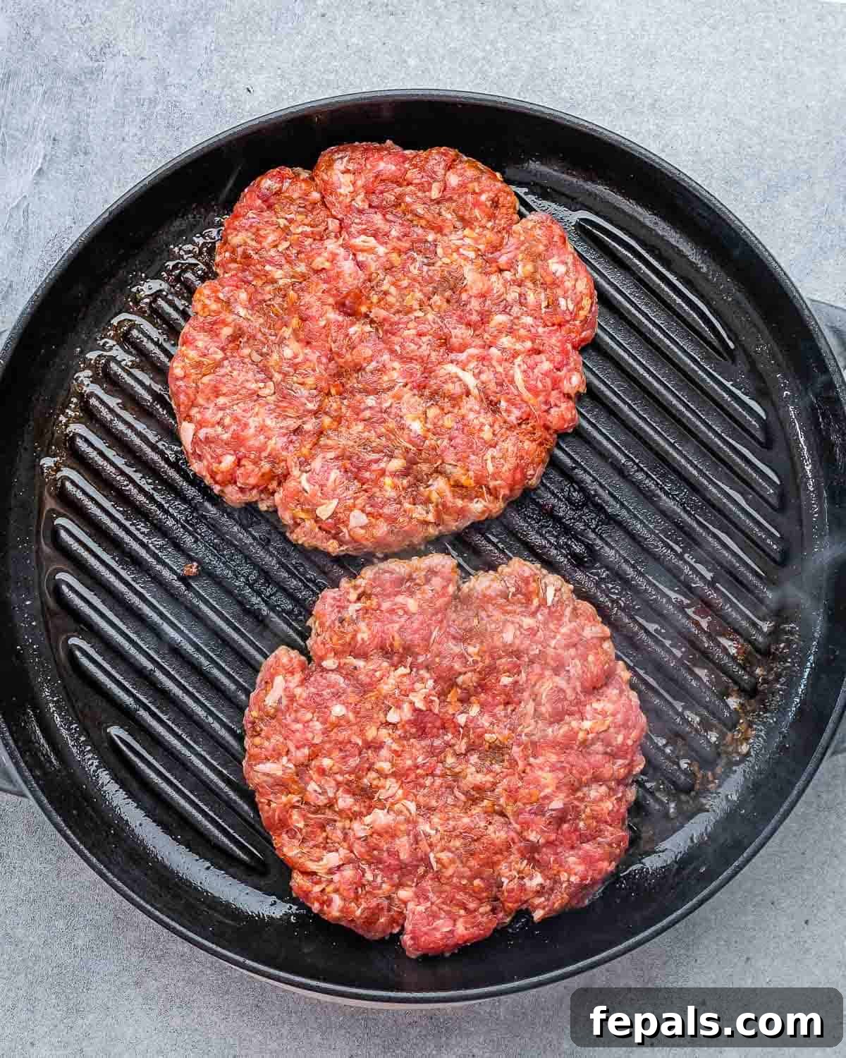 Burger Perfection, Made Easy 5 Raw ground beef patties cooking on a grill pan.