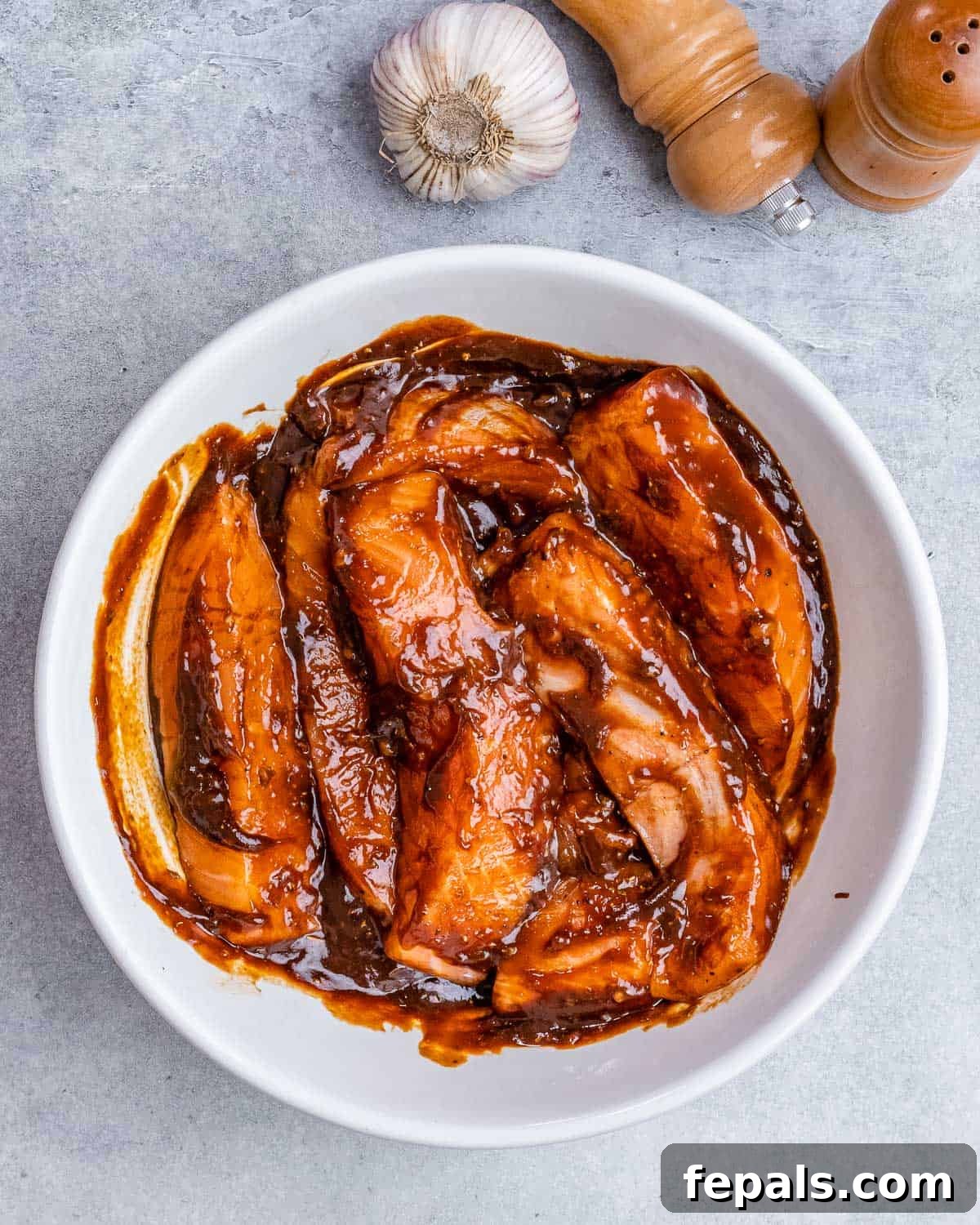 Marinating salmon filets in a white bowl.