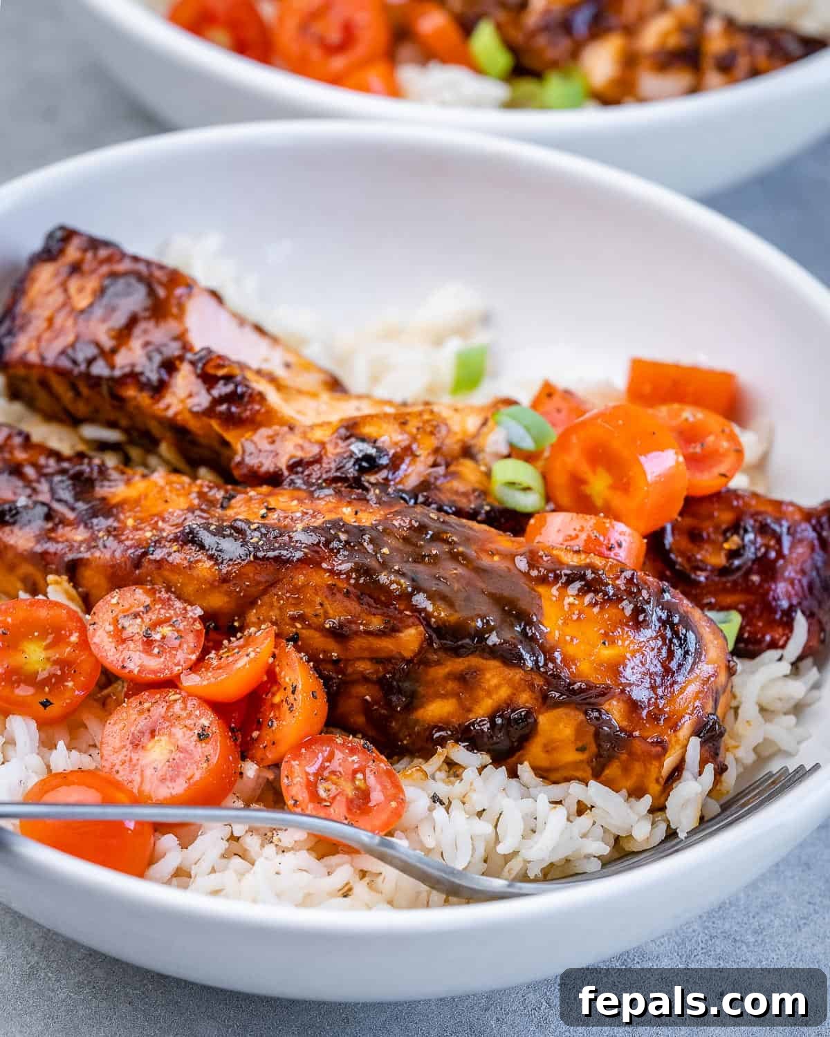 Balsamic glazed salmon served over rice with tomatoes.