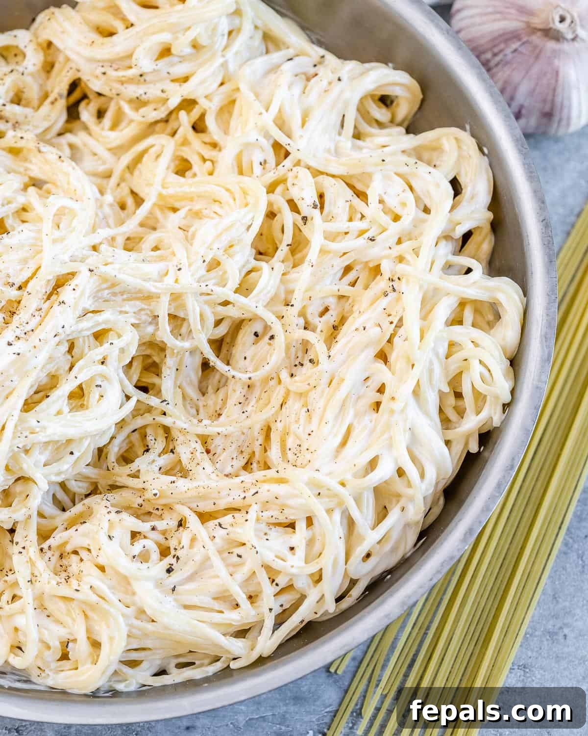 Velvety Cottage Cheese Alfredo 2 Overhead image of Alfredo spaghetti served in a bowl and topped with grated parmesan cheese.
