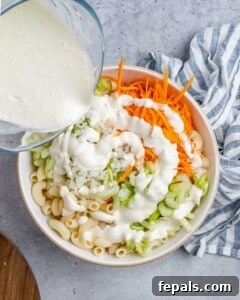 Aloha Macaroni Salad 14 Pouring the mayo and milk dressing over the chopped veggies and macaroni in a mixing bowl.