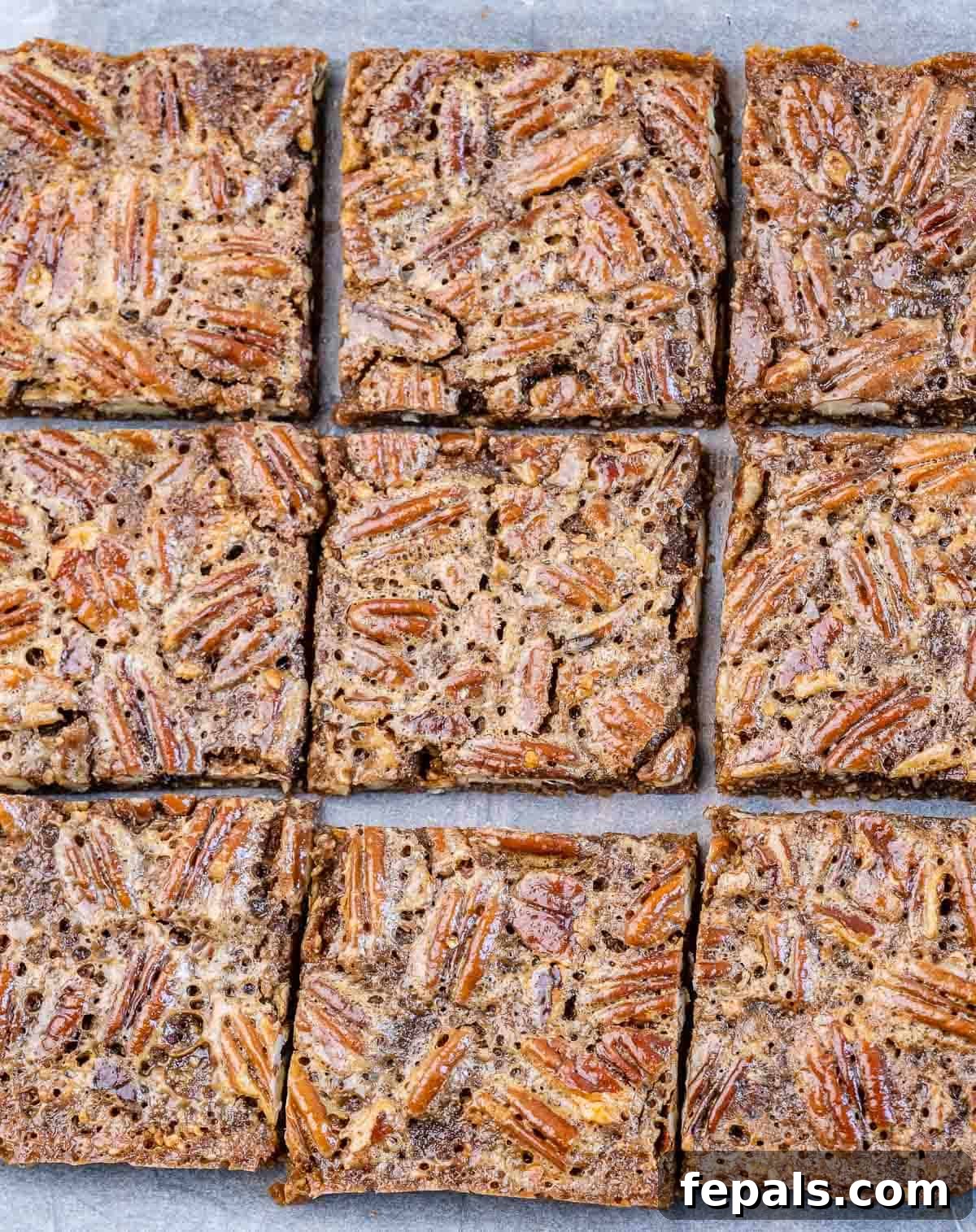 Healthy pecan pie bars on parchment paper.