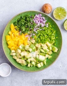 Chopped mango and veggies in a bowl to make salsa.