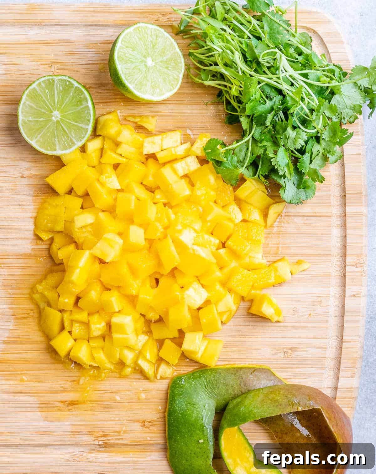Chopped ripe mango on a cutting board, ready for the salsa.
