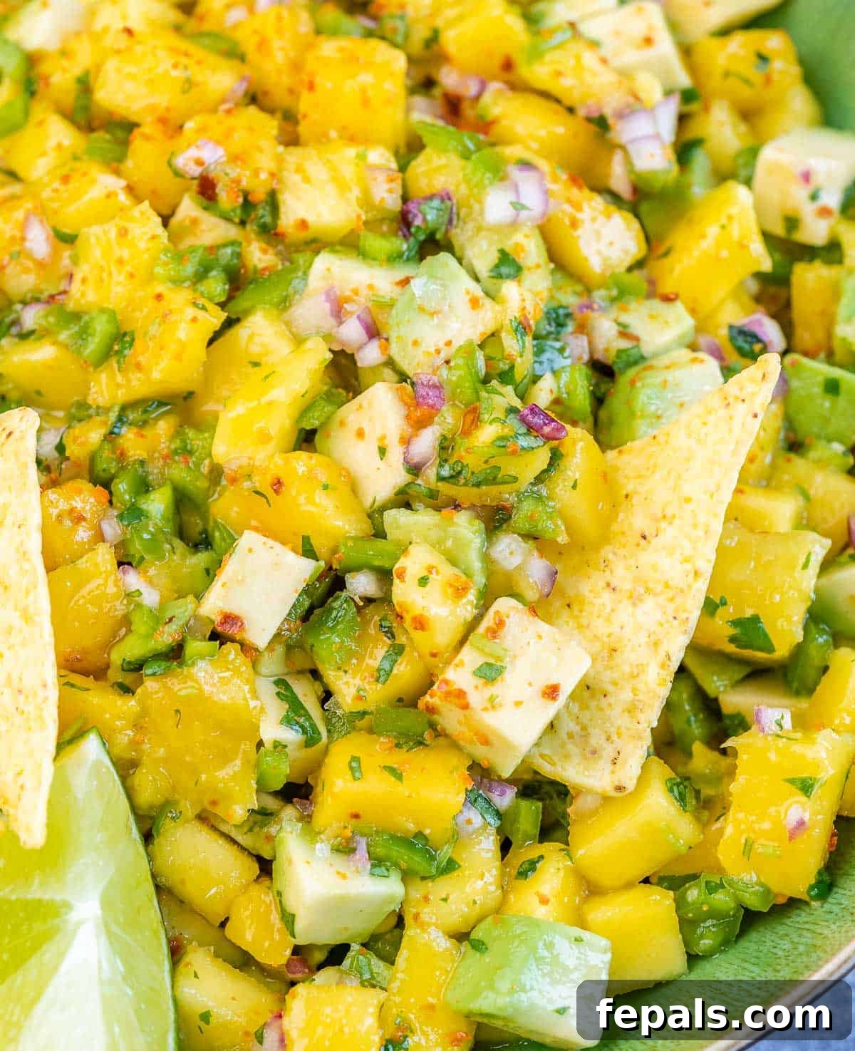 A close-up of fresh mango salsa in a bowl, highlighting its vibrant ingredients.
