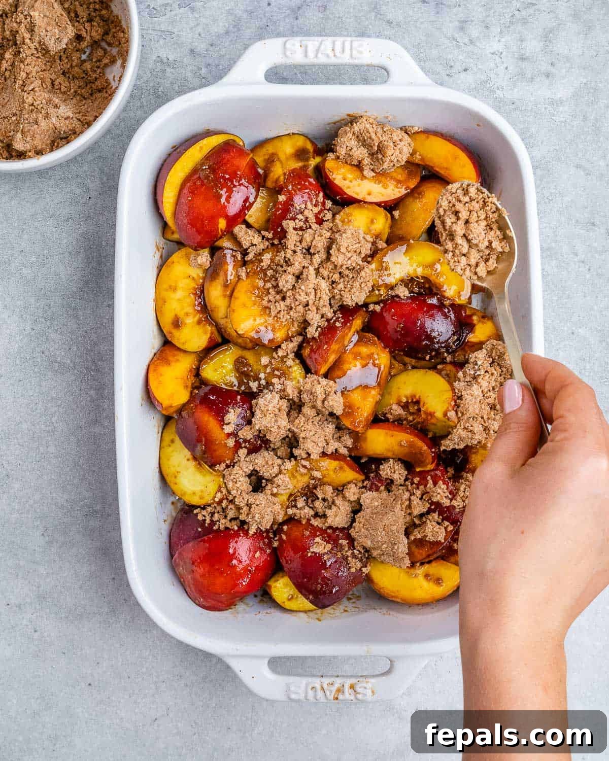 Wholesome Peach Cobbler 6 Adding the cobbler topping over sliced peaches.