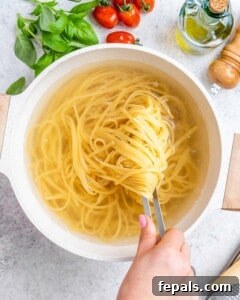 Fresh and Fast Tomato Basil Pasta 10 Cooked spaghetti lifted from pot with tongs.