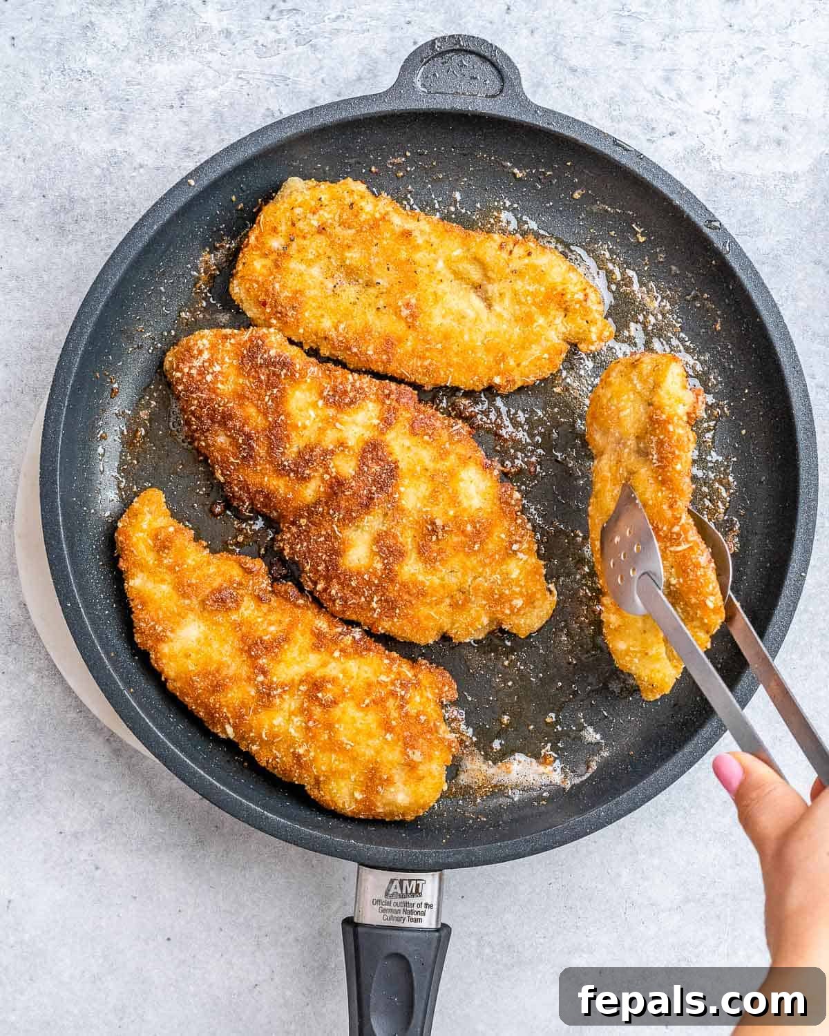 Ultimate Chicken Parm Bake 6 Cooking breaded chicken in a skillet until golden brown.