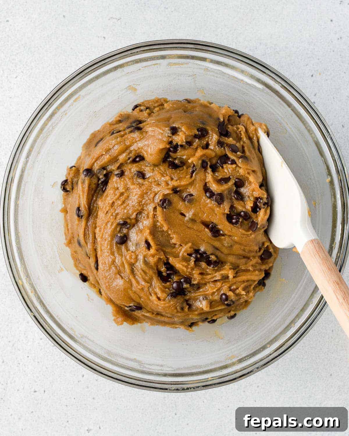 Liquid Gold Chocolate Chip Cookies 8 Cookie dough with chocolate chips in a large bowl.