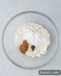 flour and spices are added to a bowl.