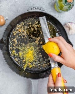 Garlic sautéing in olive oil with lemon zest being added into the pan.