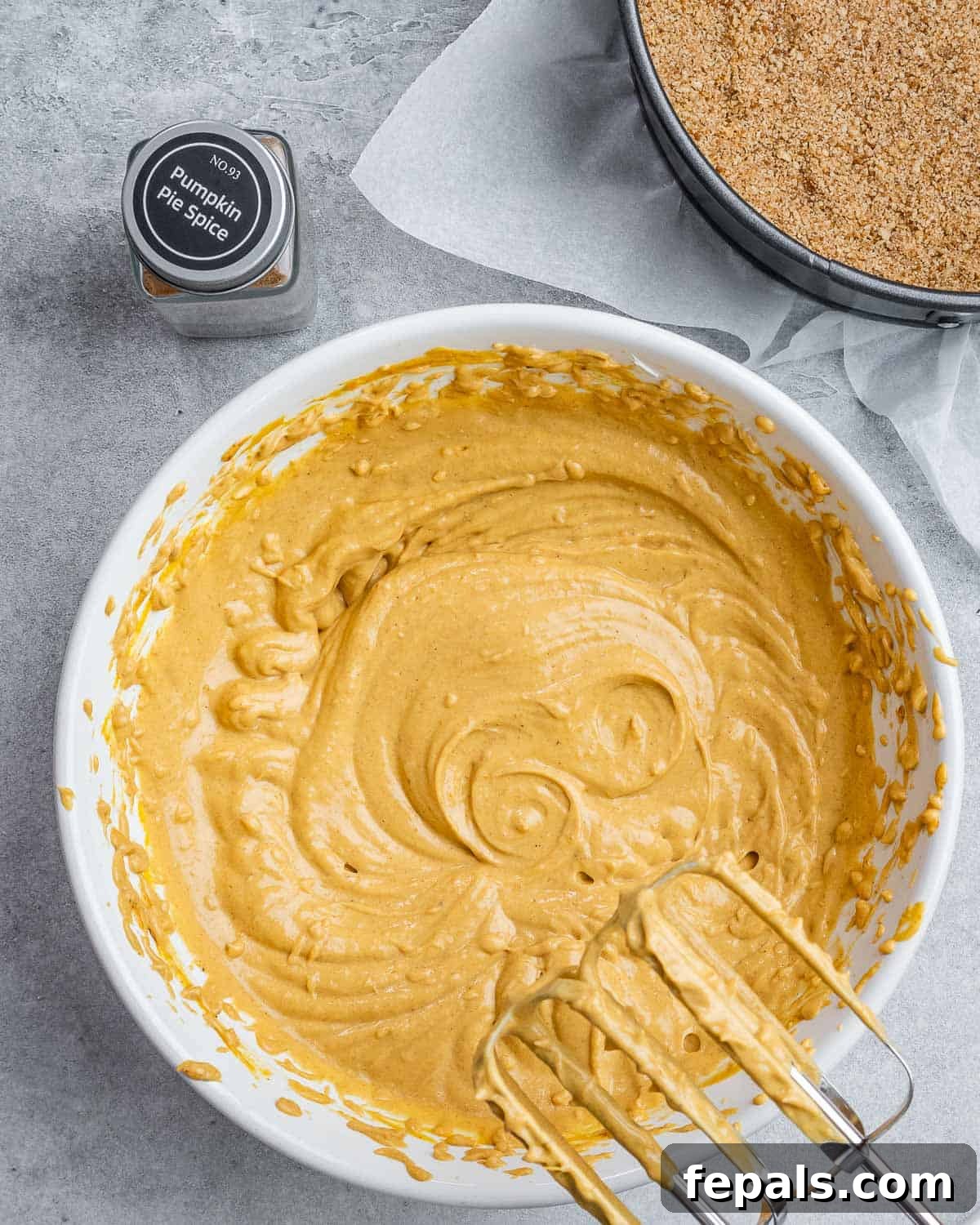 Using a mixer to beat pumpkin with cream cheese.