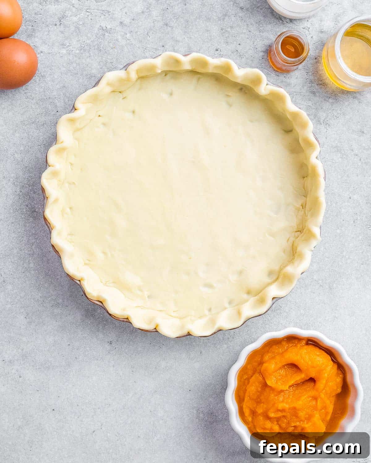 Wholesome Pumpkin Pie 4 A pie crust meticulously pressed into a pie plate, with crimped edges, ready for the filling.