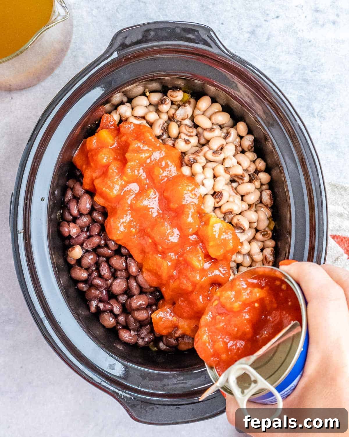Easy Crockpot Chili 6 Transferring sautéed beef and vegetables from a skillet to a slow cooker.