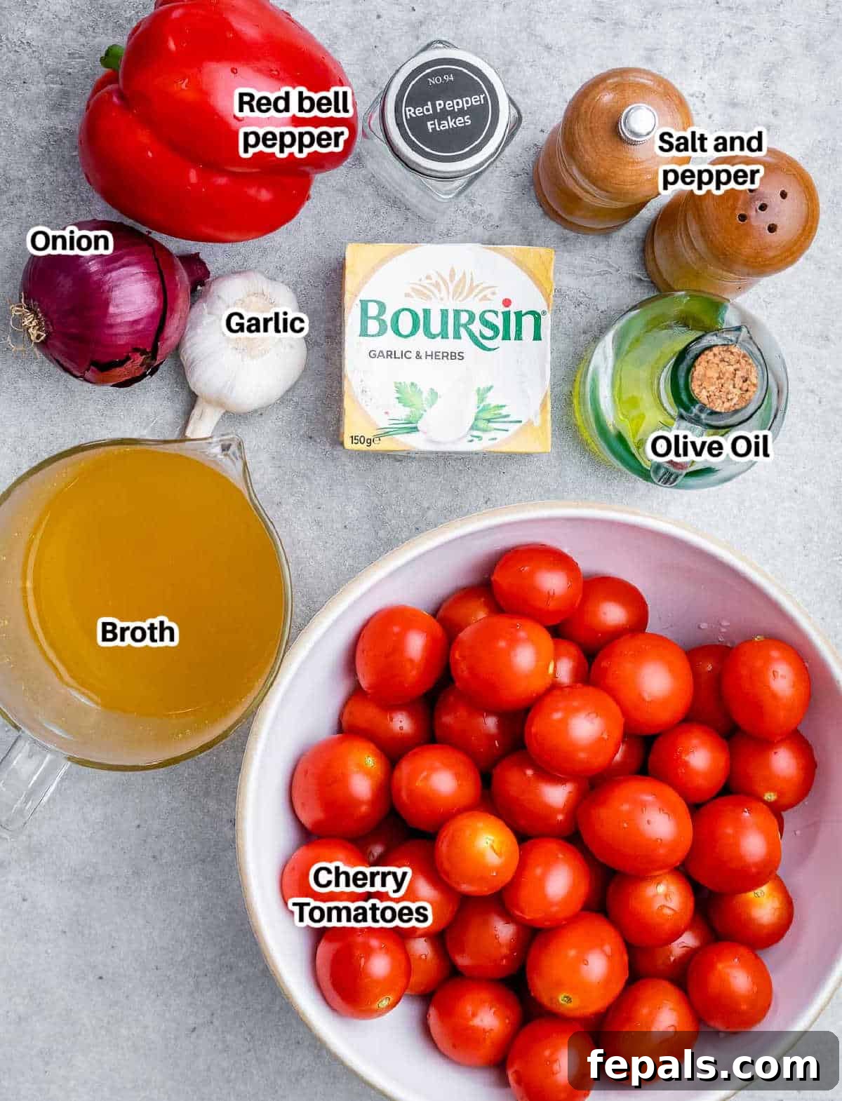 Smoked Tomato Bisque 4 A vibrant display of fresh ingredients for tomato soup, including cherry tomatoes, red onion, bell pepper, garlic cloves, olive oil, and Boursin cheese on a rustic wooden board.
