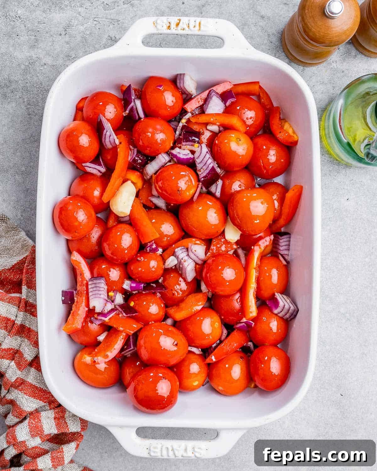 Smoked Tomato Bisque 5 Tomatoes, onions, and peppers mixed with herbs in a white baking dish, ready for roasting.