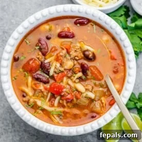 a white bowl of chili with spoon in the bowl.