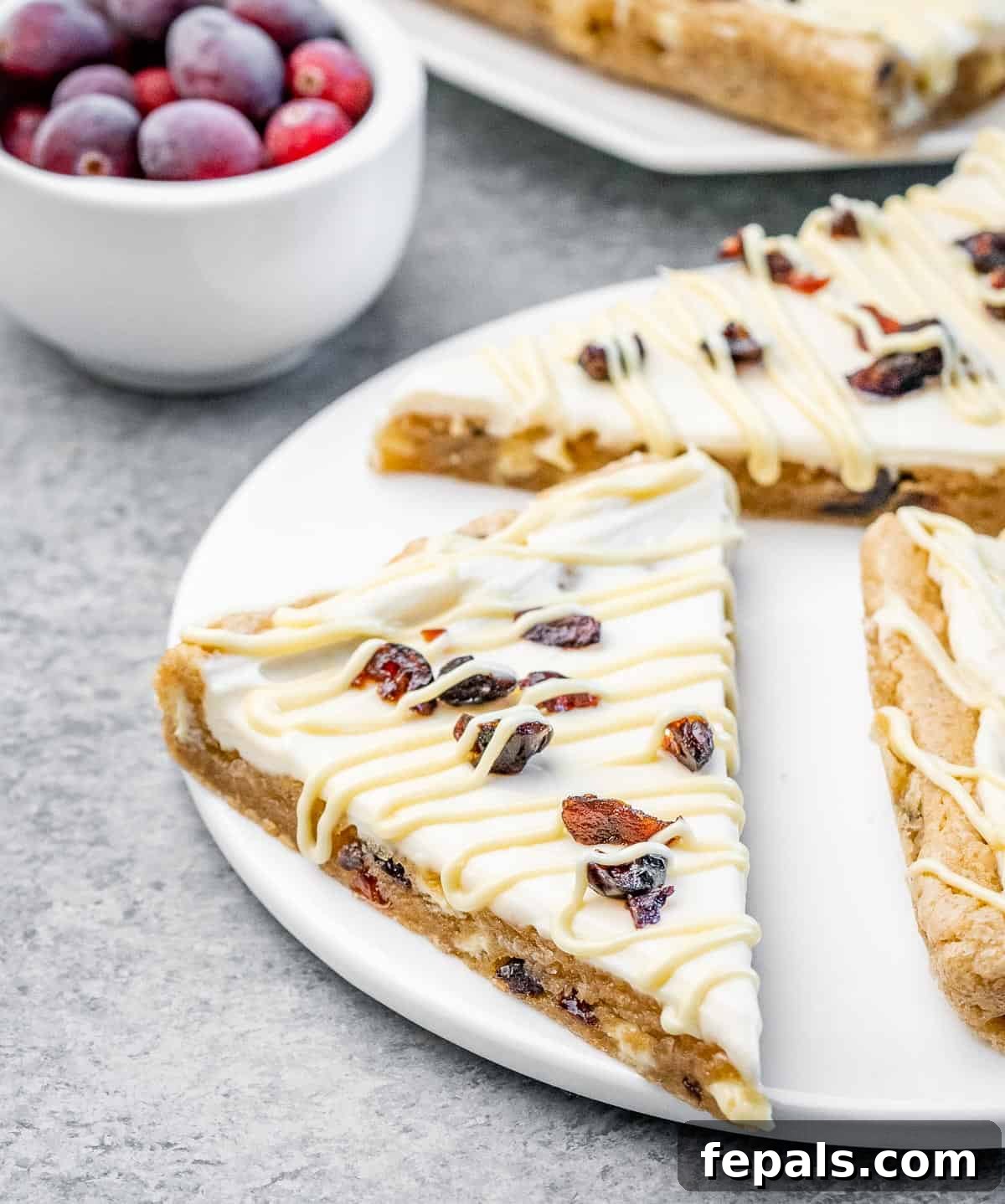 A stack of cranberry bliss bars on a plate, ready to be enjoyed.