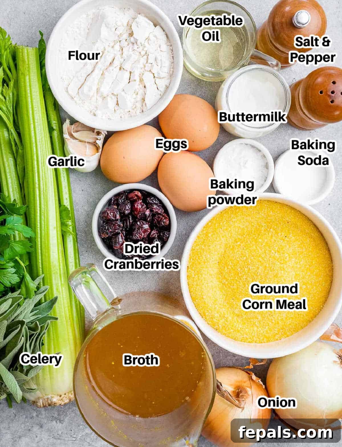 Various ingredients for cornbread stuffing laid out on a wooden surface.