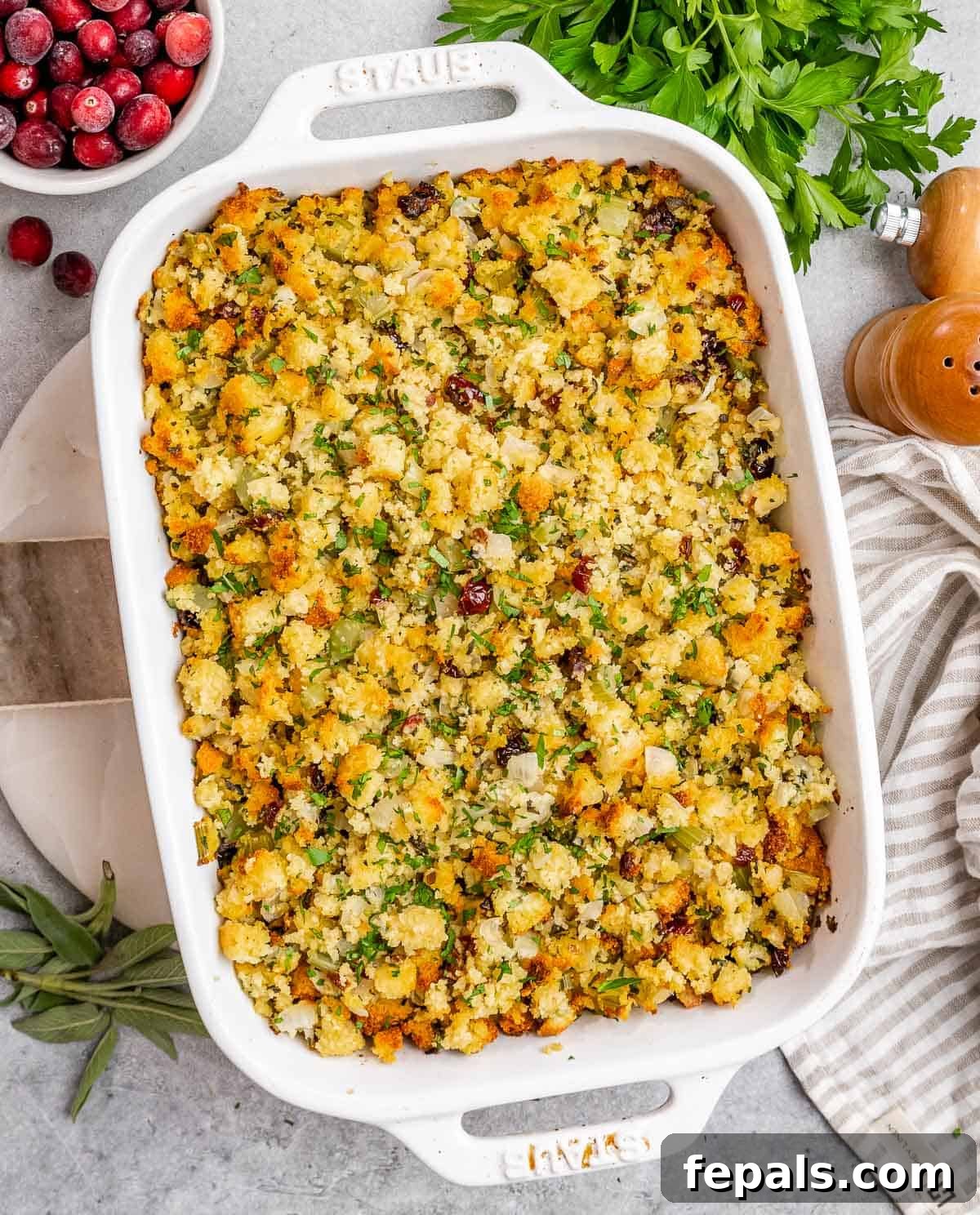 Baked cornbread stuffing in a white rectangular casserole dish, ready to serve.