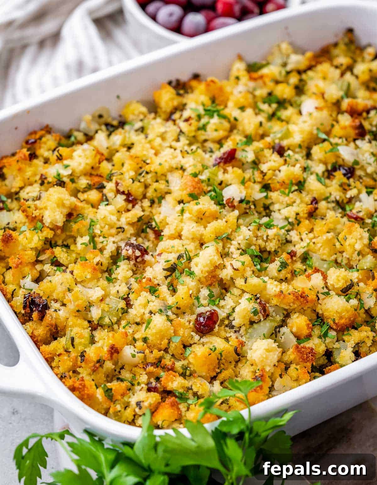 Large white casserole dish filled with golden-brown cornbread stuffing.