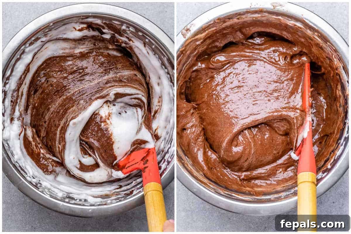 Process shot of mixing the lightened chocolate base into the stiff egg whites to create the final airy soufflé batter.