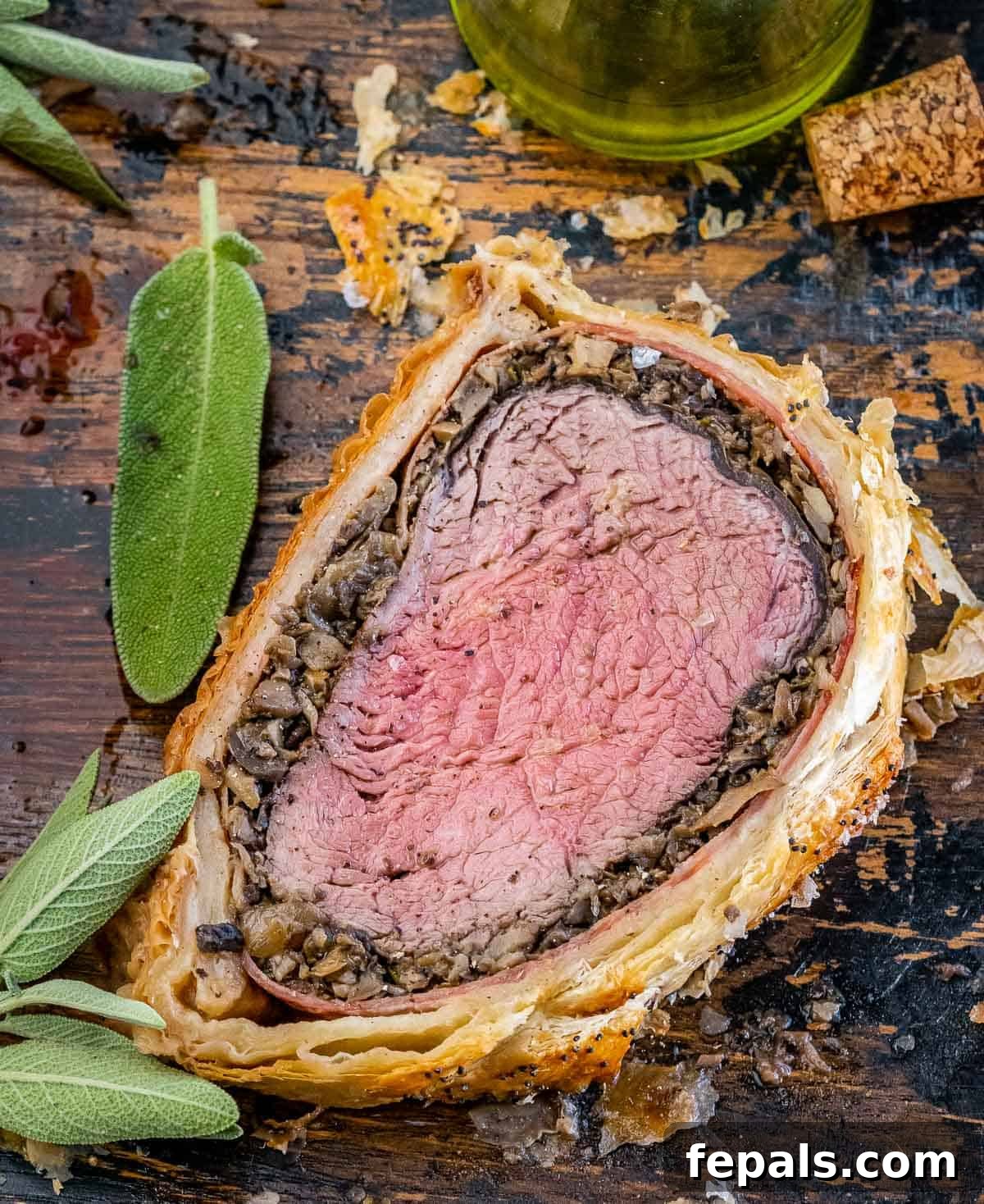 Regal Beef Wellington 9 A single, thick slice of Beef Wellington served on a brown cutting board, showing its layered interior.