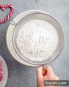 flour being sifted over the fluffy egg and sugar mixture.
